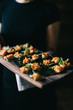 © CWP, LLC/Stocksy - Server passing appetizers