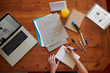 © guille Faingold/Stocksy - Crop woman with studies at table from above