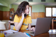 © guille Faingold/Stocksy - Casual student having phone call and using laptop