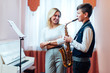 © Аrtranq - Cheerful teacher with student boy learning saxophone lessons at school