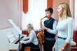 © Аrtranq - Boy student learns to play the saxophone in a music lesson to accompaniment of the piano.