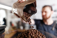 Man Adding Coffee Beans Into Container