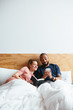 © Bonninstudio/Stocksy - Multiethnic lovers on bedroom.
