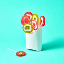 White Cardboard Box With Colorful Lollipops On A Blue Background With Space For Text