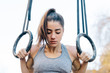 © Javier DÌez/Stocksy - Sportive woman hanging on gymnastic rings