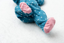 A Newborn Baby Laying On A Bed With A Polka Dot Jammies