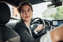 Portrait Of Caucasian Businesswoman Driving A Car In Reverse Looking On Back Window