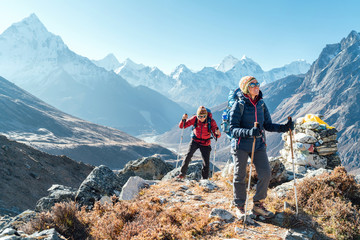 couple following everest base camp trekking route near dughla 4620m. backpackers carrying backpacks 
