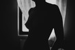© Evil Pixels Photography/Stocksy - Black and white close up of a female naked silhouette indoor