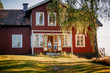 © Maskot - Mid distant view of couple standing on entrance of house in summer