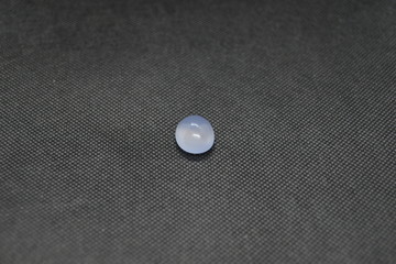 Natural Chalcedony in a shape of cobochon on black fabric background.