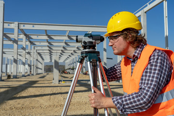 Construction Worker With Tacheometer Working at Construction Site