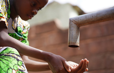 Wall Mural - Gorgeous African Black Young Girl Washing Hands Outdoors with Freshwater