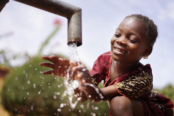 water is life for african children, little gorgeous black girl drinking from tap