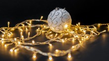 White Shiny Christmas Ornament Surrounded With Christmas Lights