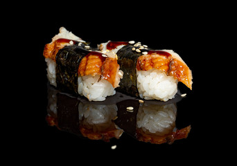 Wall Mural - sushi and rolls with different fillings on a black background with reflection