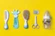 Newborn baby accesories isolated on yellow background. child comb with scissors, pacifiers and milk bottle.