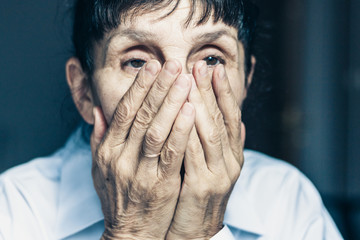 Sad depressed, stressed, thoughtful, senior, middle aged old woman, gloomy, worried, covering her face. Human expressions, emotion, feelings and reaction .