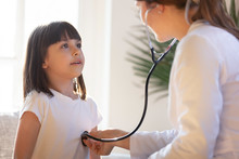 Pediatrician With Stethoscope Listening To Lung And Heart Sound Of Child