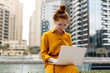© PinkCoffee Studio - Young Woman sitting in Dubai Marina aria and work on laptop. Student or  freelancer lifestyle.