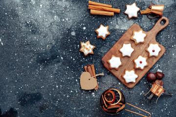 Wall Mural - Homemade Christmas star shape gingerbread cookies with frosting and cinnamon over cutting board. Top view, flat lay