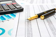 © igorkol_ter - Pen with calculator on financial graph and documents.