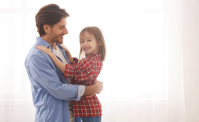 Smiling girl hugging her loving father over white background