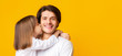 © Prostock-studio - Little girl kissing her happy father over yellow background