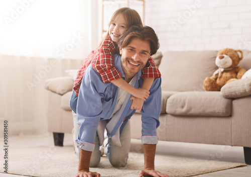 Cuadros en Lienzo Daughter sitting father back, hugging him and smiling at camera