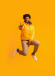 © Prostock-studio - Positive winter black guy greeting with peace gesture while jumping