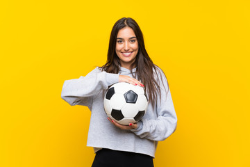 Young football player woman over isolated yellow background