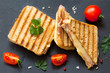 Top view photo of a club sandwich. Toasted sandwiches with salami and melted cheese on black background.
