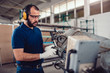 © kerkezz - Factory worker operating band saw cutting machine