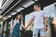 © GalakticDreamer - Cheerful couple in love rejoicing during journey travel for exploring new city and urban setting, positive Caucasian man and woman in trendy wear walking during date for flirting at urban setting