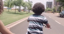 Happy Cute Boy Learn To Ride A Bike With His Mother. Mother Teaching Son To Ride Bicycle At Park. Shot On RED SCARLET-W 5K Camera. 4K.