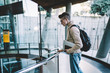 © GalakticDreamer - Young man looking down and standing on floor with glass fence