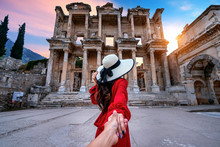 Women Tourists Holding Man's Hand And Leading Him To Celsus Library At Ephesus Ancient City In Izmir, Turkey..
