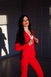 © dmitriisimakov - Portrait of a beautiful business woman brunette in a red business suit
