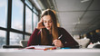 © GalakticDreamer - Thoughtful hipster girl studying at school cafeteria while reading literature and writing main theses in notebook, pensive skilled young female student learning concentrated on course work indoors