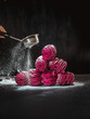 Handmade air russian fruit pink marshmallow on a black background with sugar powder. Homemade Sweets.