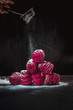 Handmade air russian fruit pink marshmallow on a black background with sugar powder. Homemade Sweets.