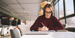 © GalakticDreamer - Young attractive hipster girl 20 years old working as interior designer and drawing sketches for house to notebook while sitting at campus cafe, woman in eyeglasses studying and writing homework