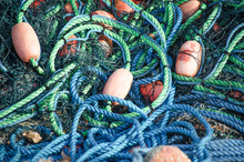 Colored Blue And Green Fishing Nets With Yellow And Orange Floats Close-up. Bright Multi-colored Backdrop. Hobby Fishing Concept. Copy Space.