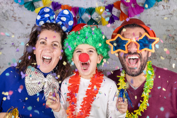 Happy disguised family celebrating carnival at home.