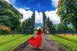 Woman walking at big entrance gate, Bali in Indonesia.