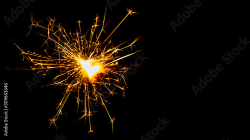 Fotomural Sparkling sparkler on a black background. New Year theme.