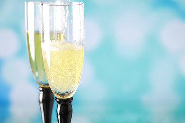 Background with tall glasses for sparkling wines. Champagne and spray in glass glasses. Celebratory drink with reflection.