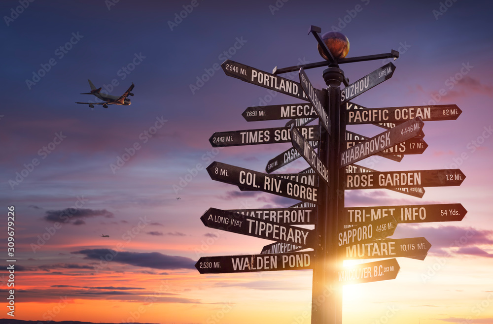 World Traffic signs and directional signpost pointing to famous travel destinations with blue cloudy sky and free copy space for text on the right - obrazy, fototapety, plakaty 