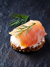 Smoked Salmon Canapé With Cream Cheese On Black Stone Background. Close Up. 