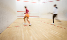 Two Female Squash Players In Action On A Squash Court (motion Blurred Image; Color Toned Image)
